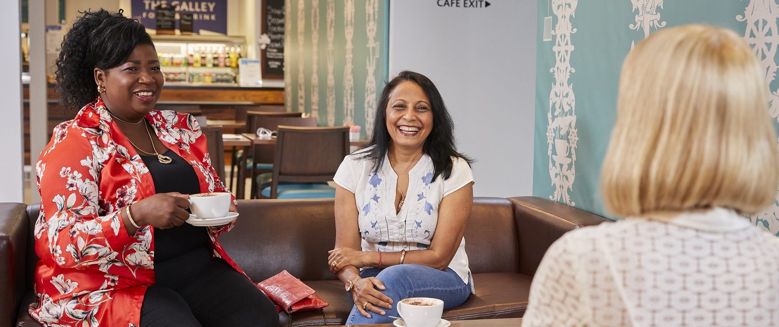 3 ladies drinking coffees round a table