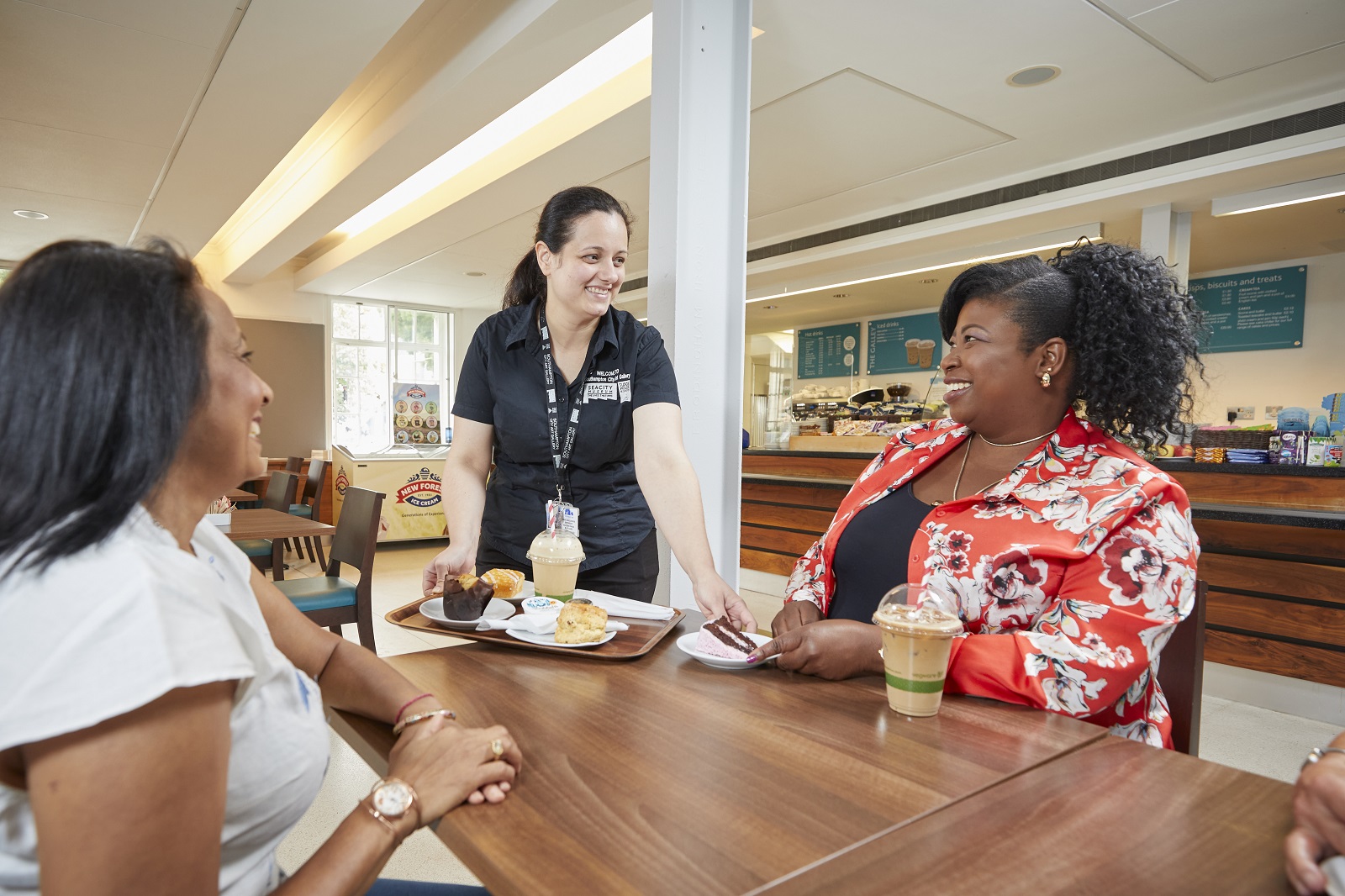 Cashier bringing a tray of food over to table