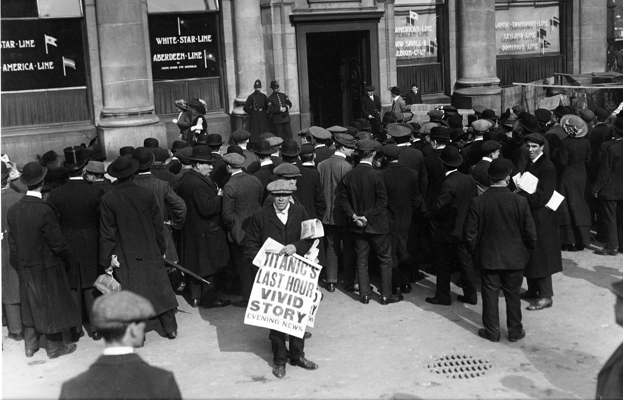 Black and white photo of newsboy showing Titanic disaster newspaper